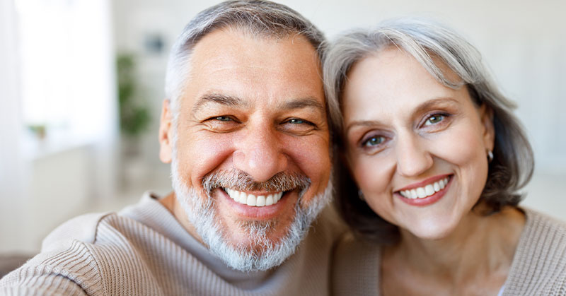 A happy couple smiling on camera - Dental-Implants