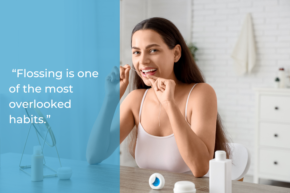 Woman with long hair in a white tank top flossing her teeth in a bathroom, dental products on the counter, and a quote about dental habits for a healthier smile on the left side of the image.